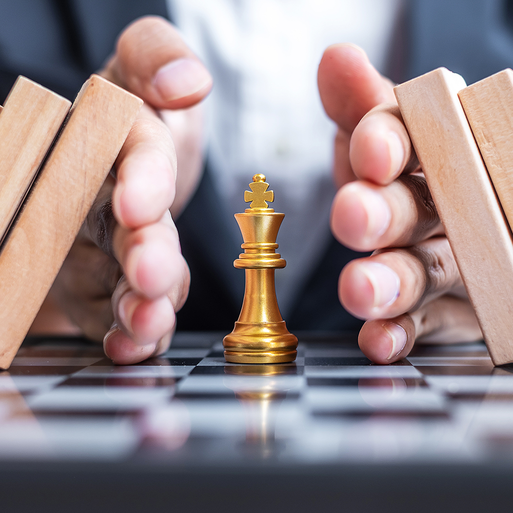 Business man hand protect Chess King figure and Stopping Falling